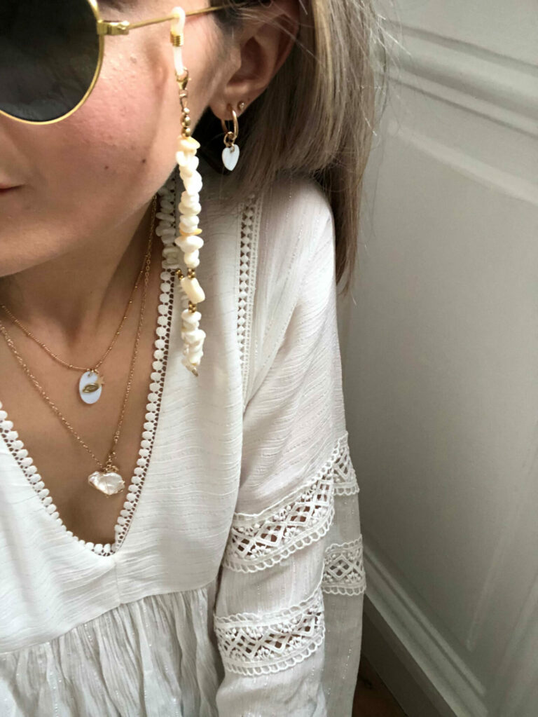 Chaîne de lunettes élégante portée par une femme, alliant bijou et accessoire pratique